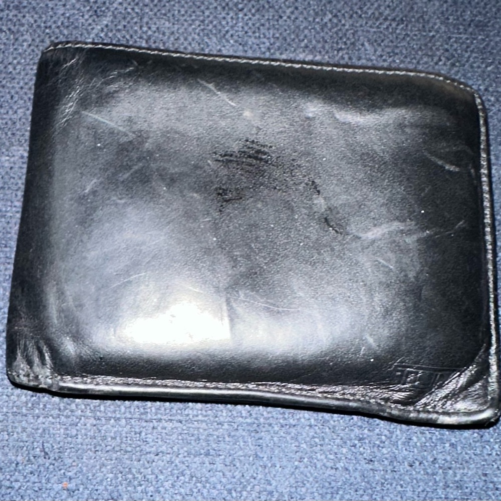 Tumi, black, leather bill-fold men’s wallet.